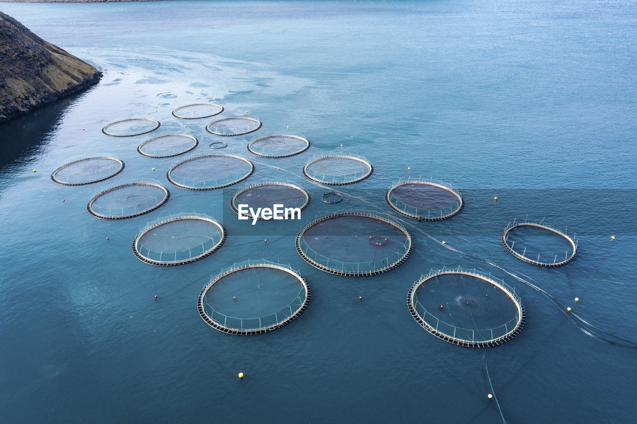 Salmon fish farm in ocean water near coast of streymay island
