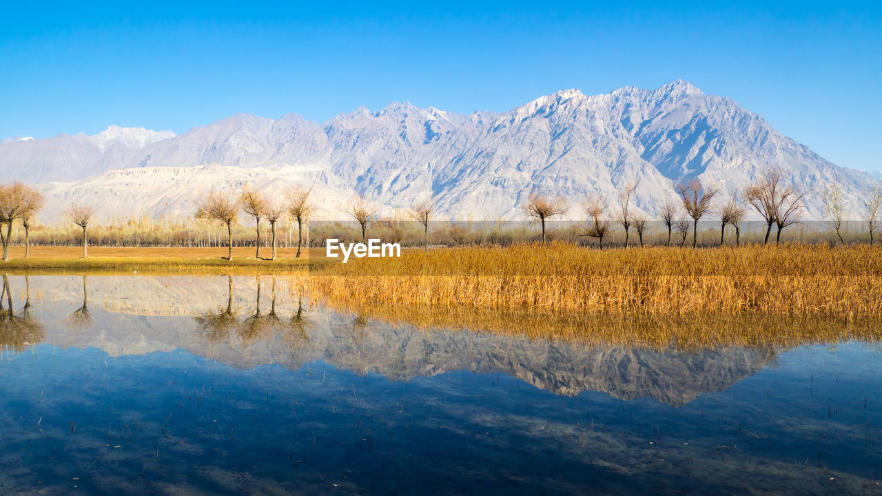 Scenic view of lake against clear blue sky