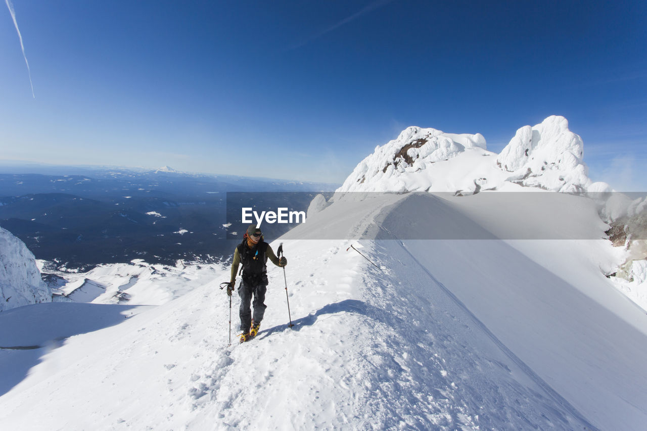 A man climbs to the summit of mt. hood in oregon.