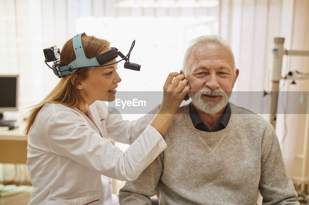 Ent physician examining ear of a senior man