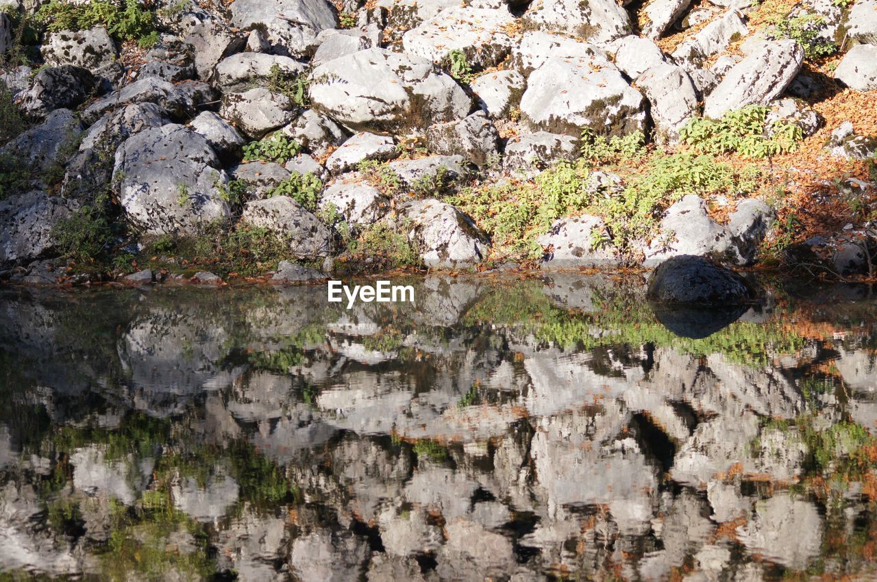 Reflection of rocks on pond