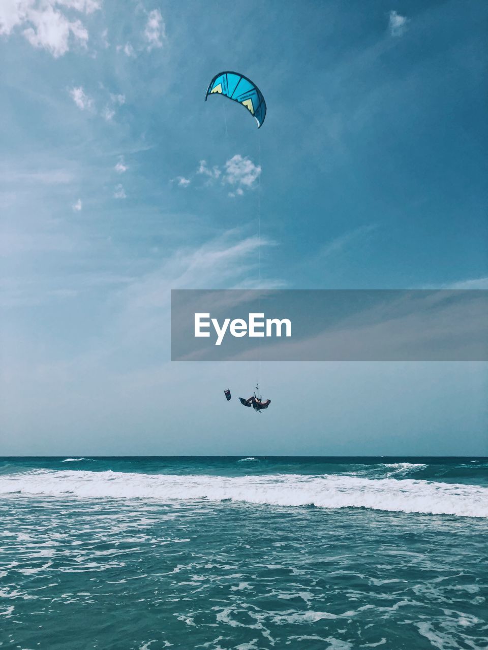 PEOPLE PARAGLIDING AGAINST SEA