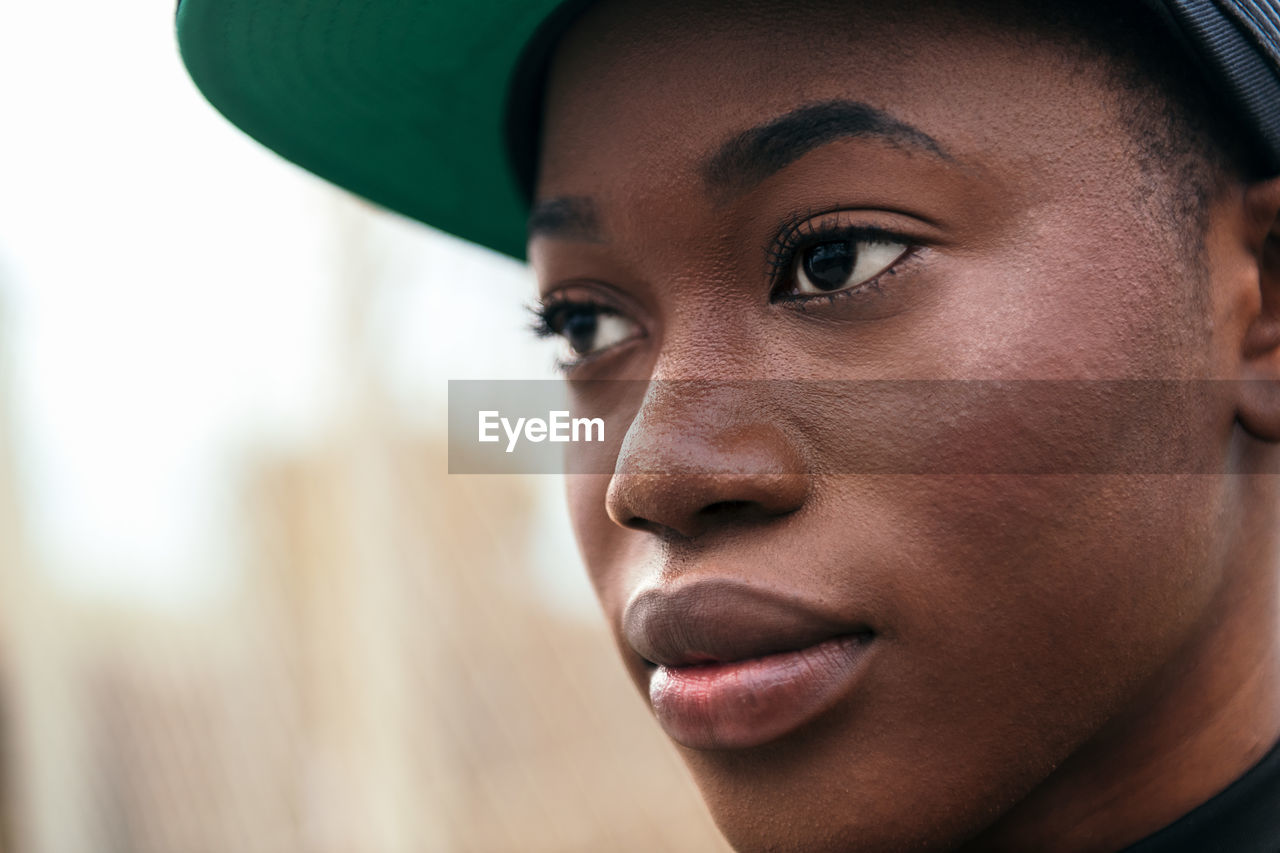 Young african american female in casual wear looking at camera with finger up in daylight