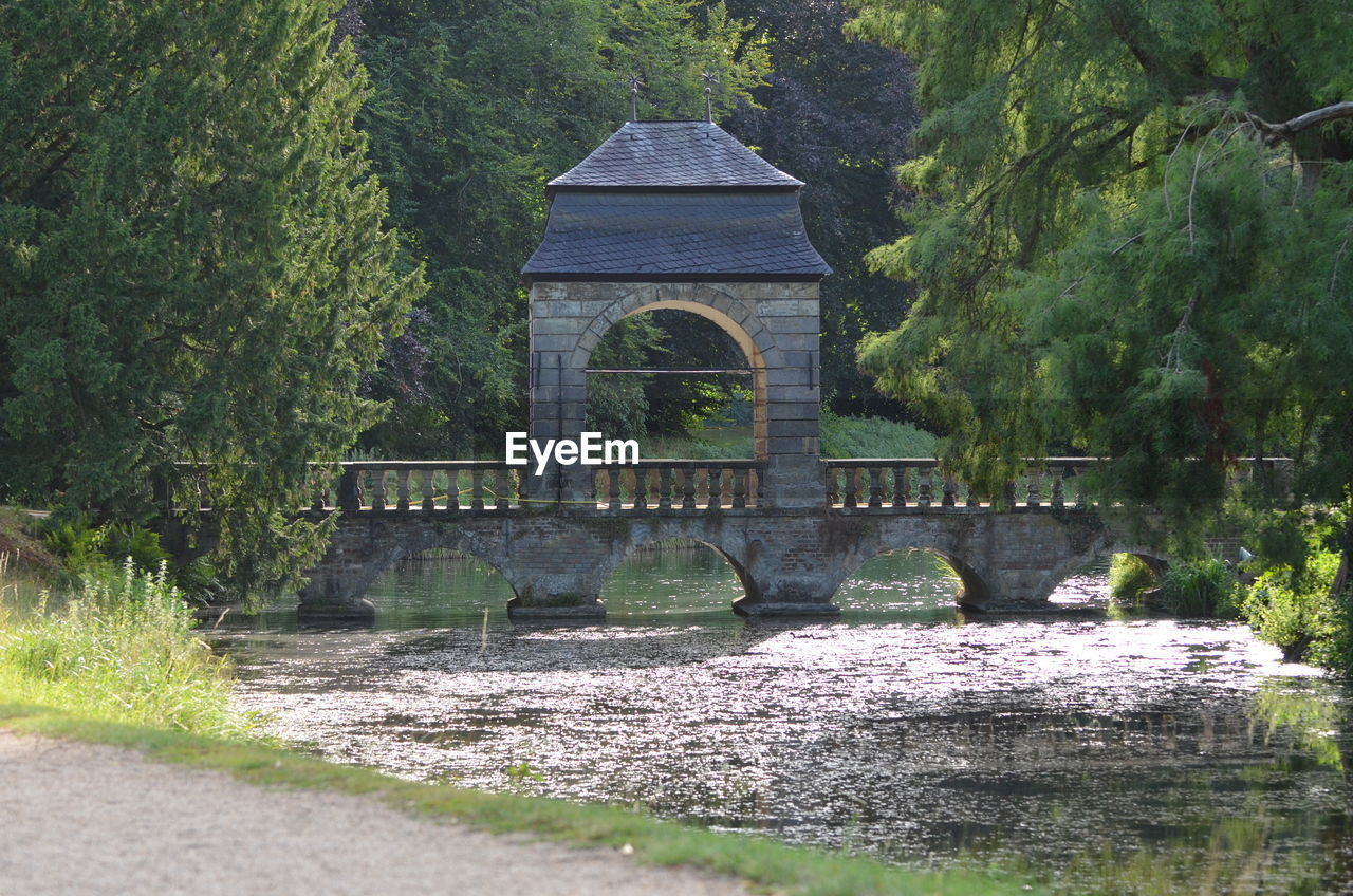 BRIDGE OVER LAKE AGAINST TREES
