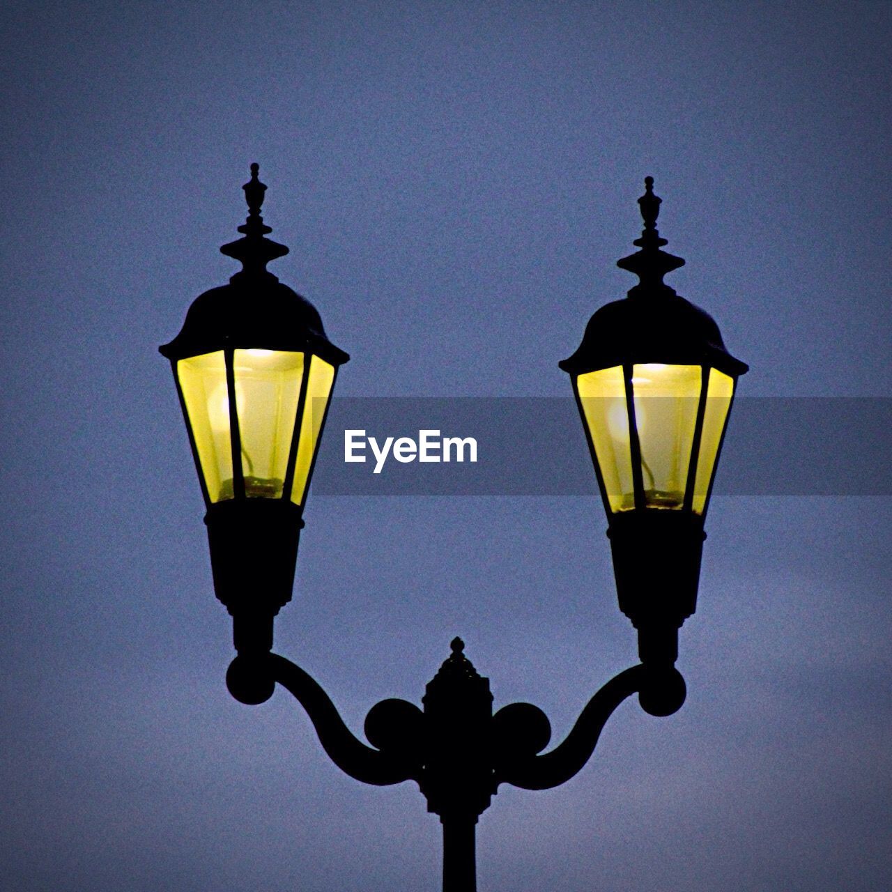 LOW ANGLE VIEW OF ILLUMINATED STREET LIGHT AGAINST SKY