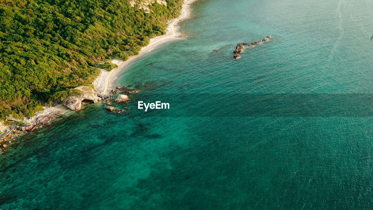 HIGH ANGLE VIEW OF PEOPLE SWIMMING IN WATER