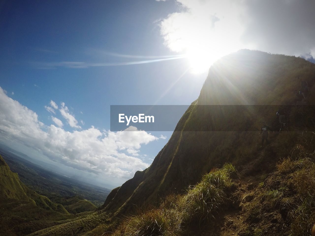 Scenic view of mountains against sky in sunny day