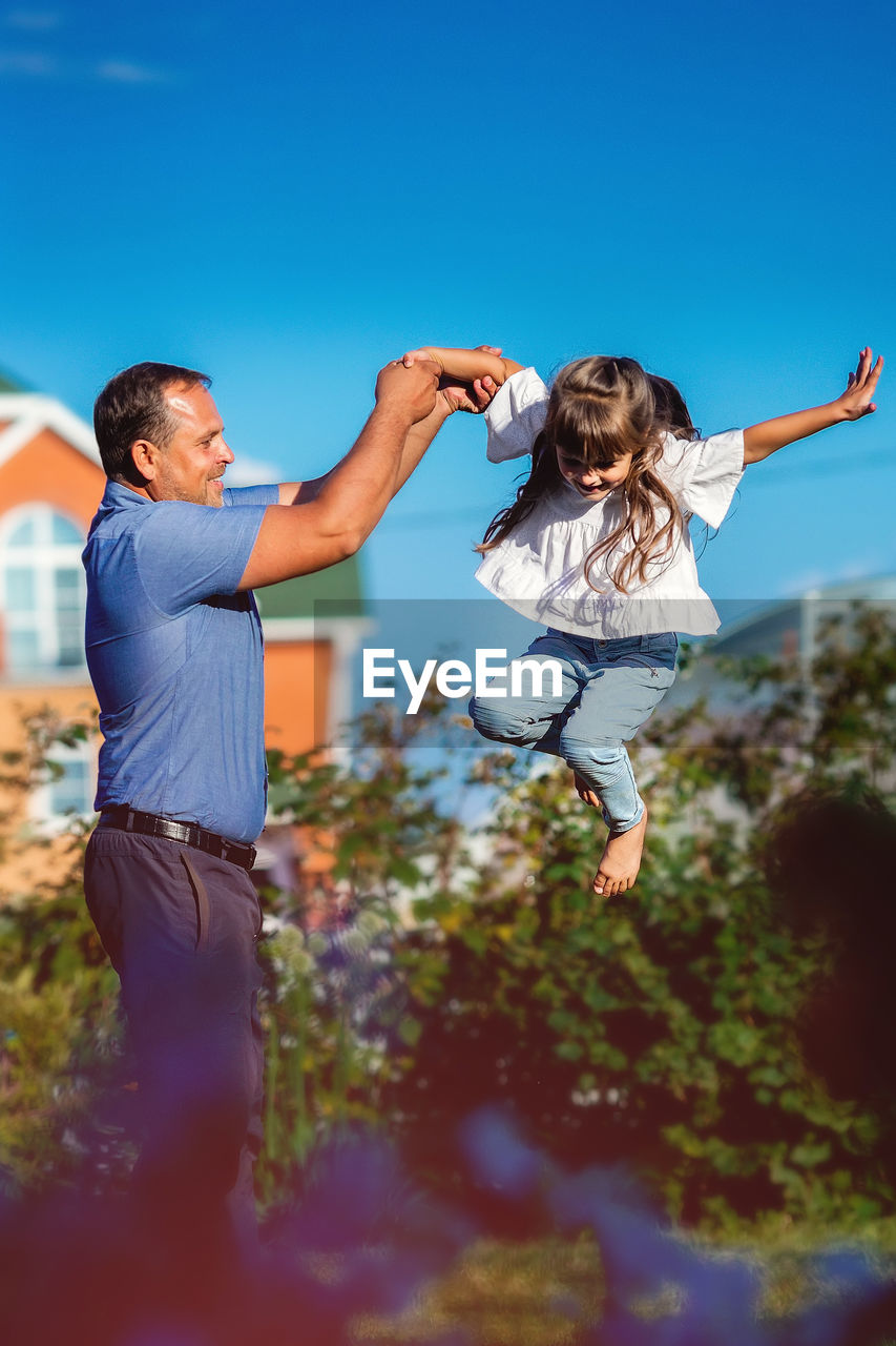 Father playing with daughter outdoors