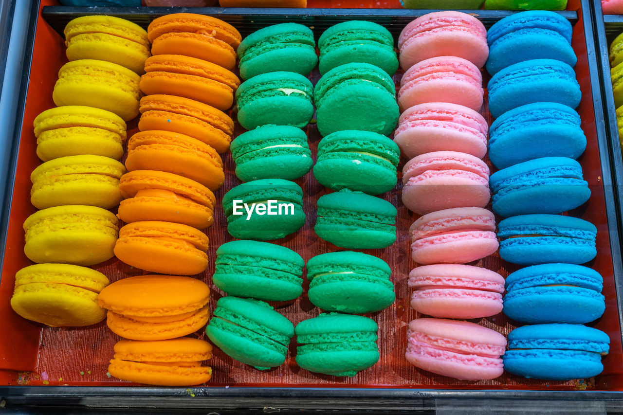 Lovely and multicolored macaroon cakes in tray at bakeshop