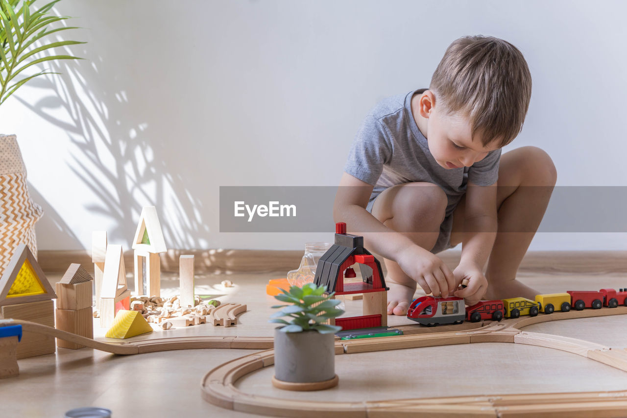 side view of cute boy playing with christmas tree at home