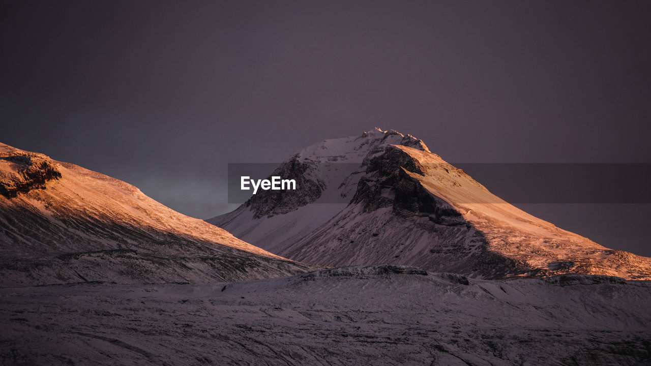 Scenic view of snowcapped mountains against sky during sunset