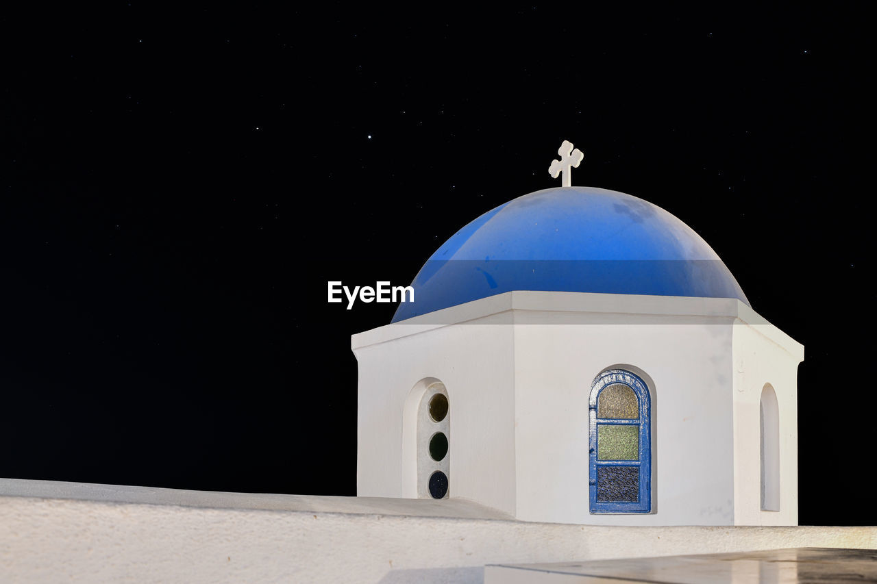 LOW ANGLE VIEW OF WHITE BUILDING AGAINST BLACK BACKGROUND