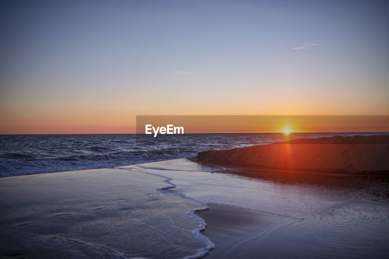 SCENIC VIEW OF BEACH DURING SUNSET