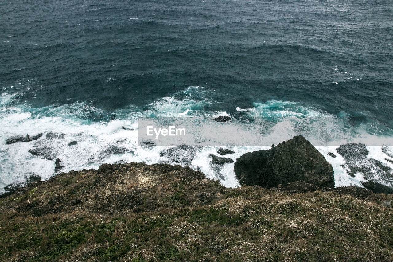 HIGH ANGLE VIEW OF ROCKS ON SHORE