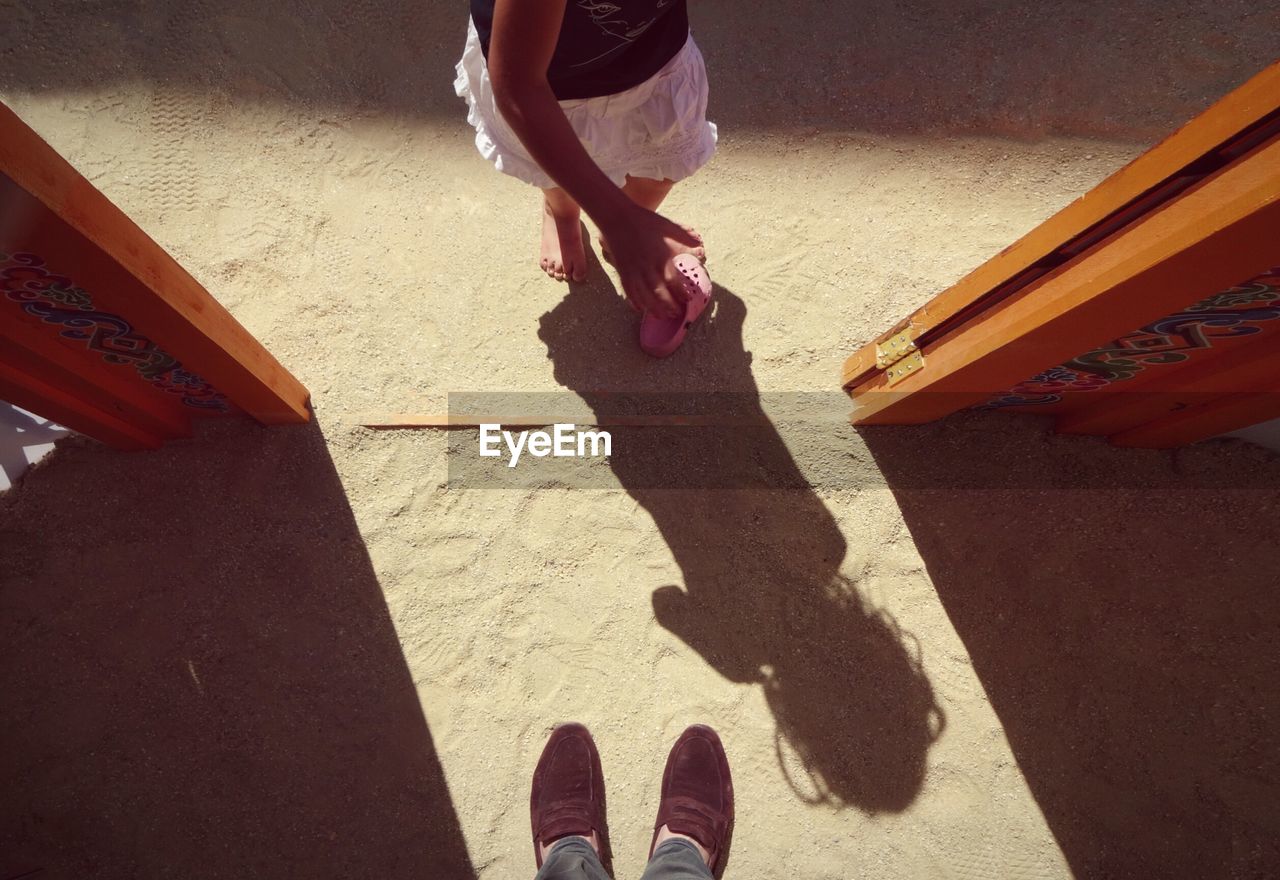 High angle view of girl standing at doorway in sand