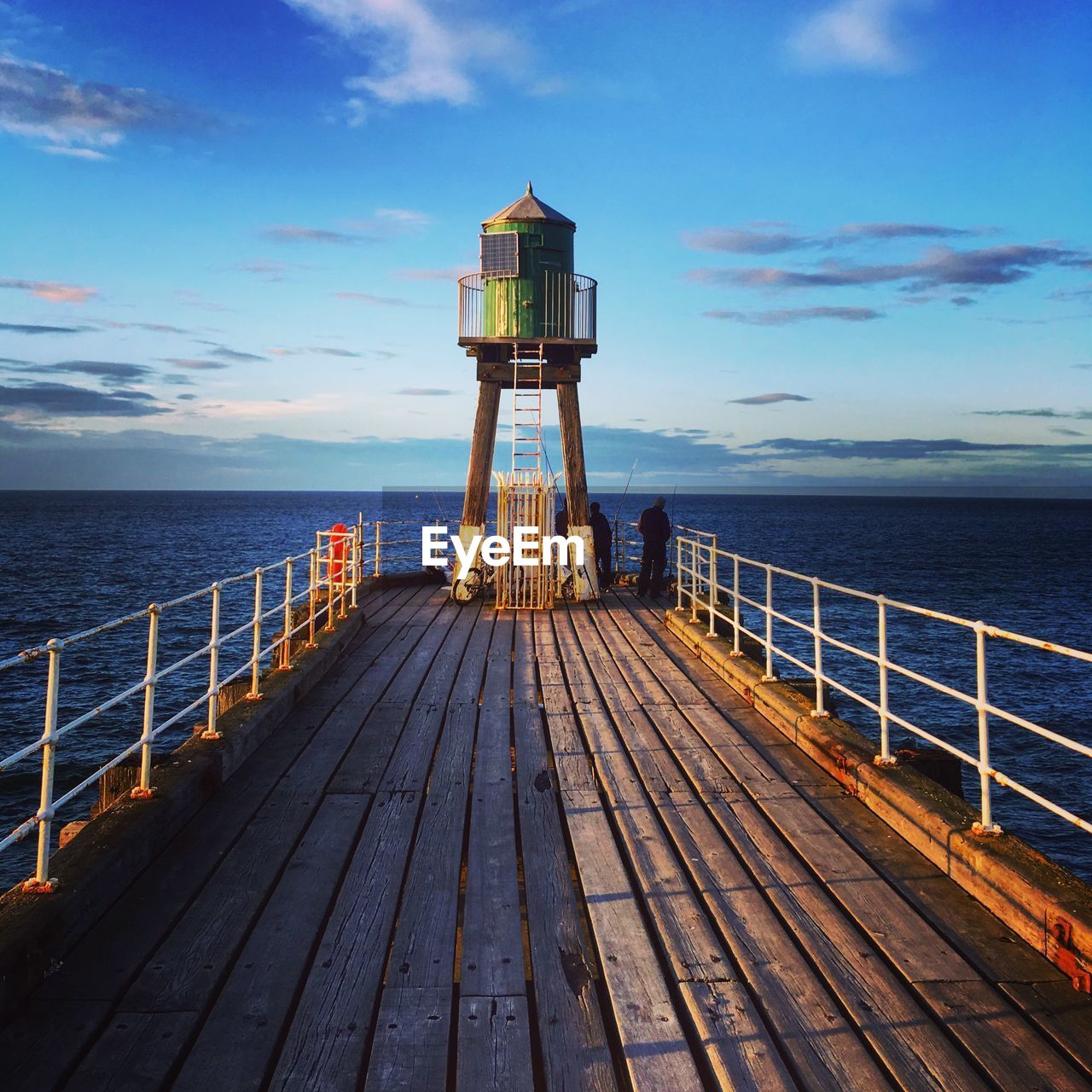 PIER AMIDST SEA AGAINST SKY AT SUNSET