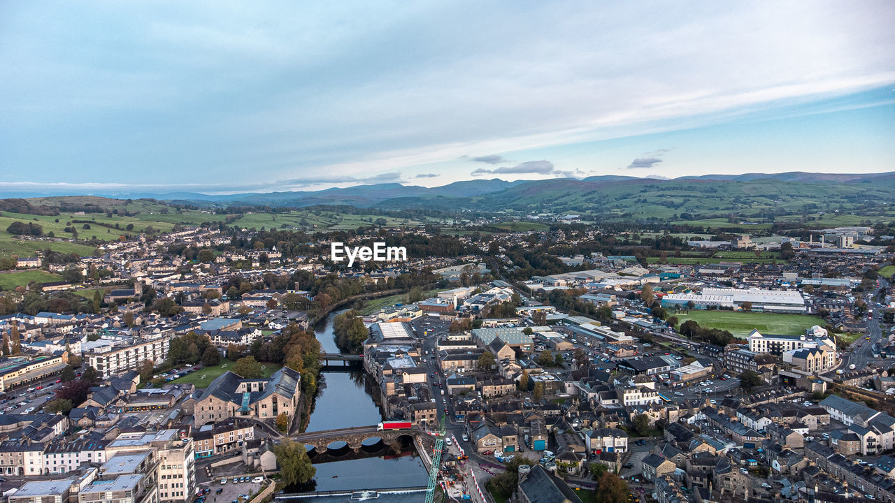 architecture, aerial photography, city, built structure, cityscape, building exterior, sky, bird's-eye view, building, high angle view, town, nature, aerial view, travel destinations, cloud, urban area, environment, landscape, residential district, residential area, water, travel, transportation, no people, skyline, outdoors, tourism, horizon, business finance and industry, street, city life, day, house, road, urban skyline