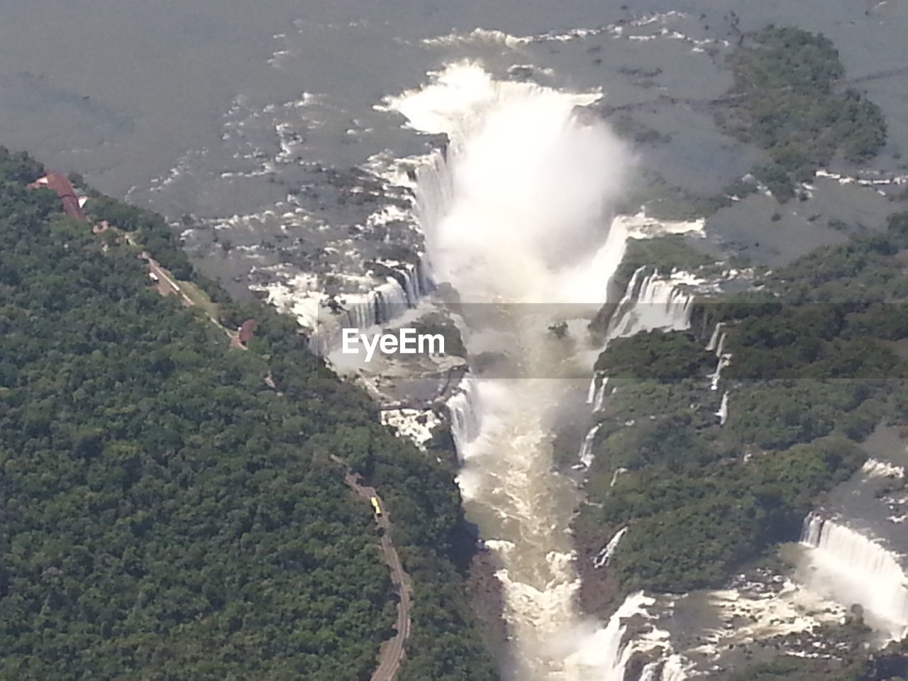 HIGH ANGLE VIEW OF WATERFALL IN SEA AGAINST SKY