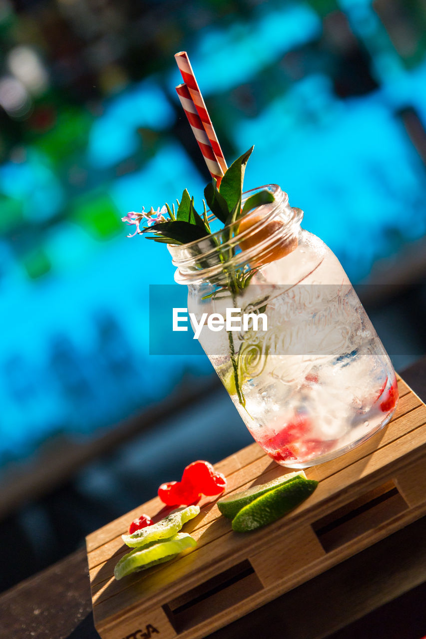 Tilt image of drink with raspberries and lemons on table