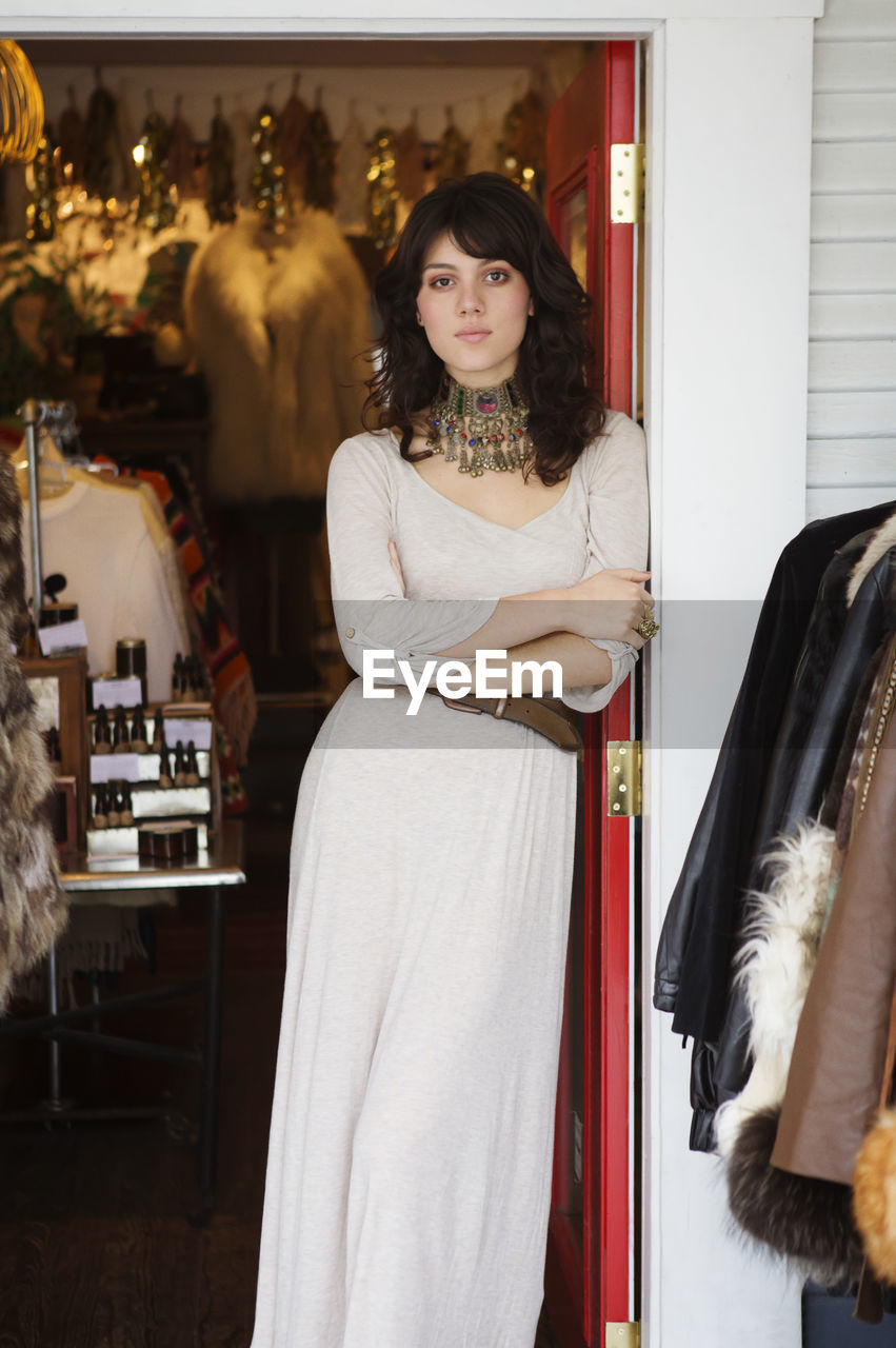 Portrait of woman standing at boutique entrance