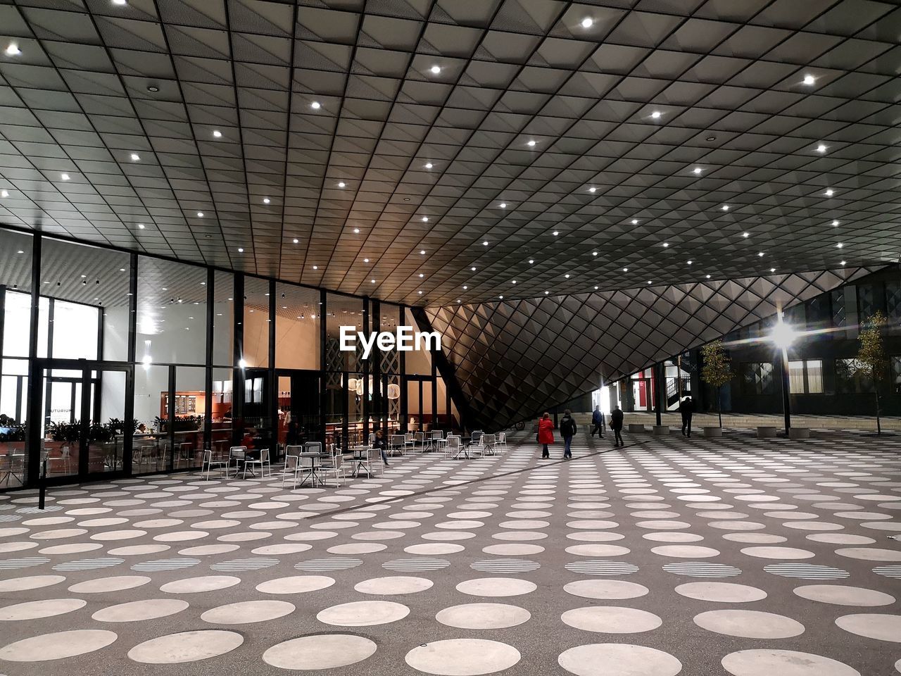 VIEW OF EMPTY CORRIDOR IN ILLUMINATED BUILDING