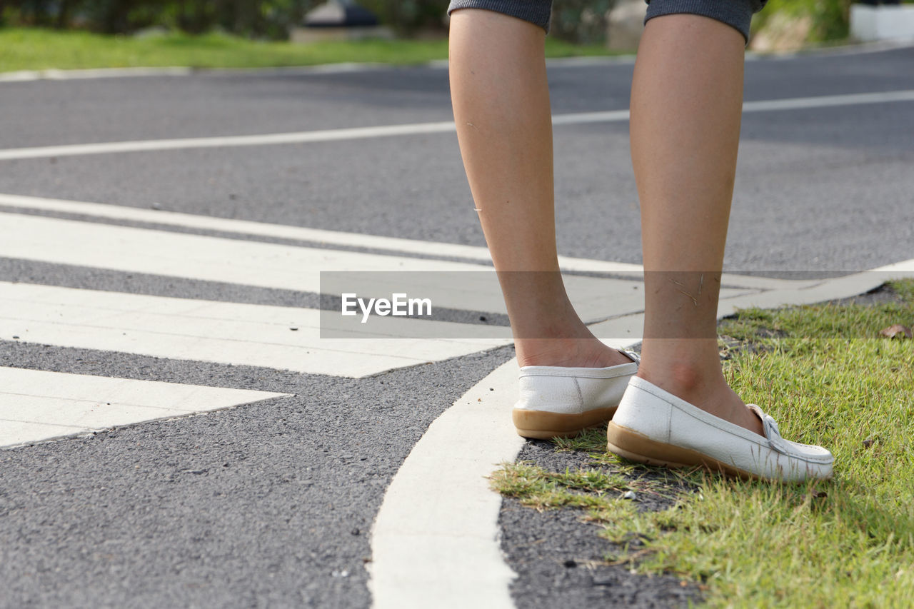 The woman sneaker shoes on the road.