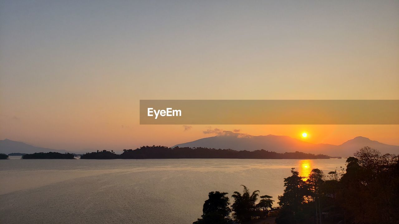 Scenic view of lake against romantic sky at sunset