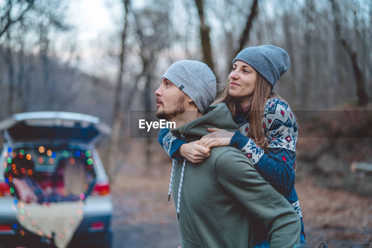 YOUNG MAN AND WOMAN STANDING IN WINTER