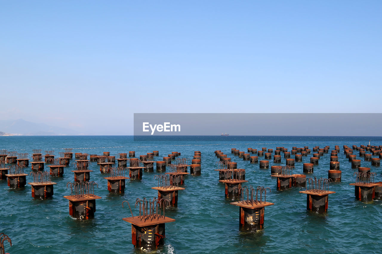 High angle view of metal structures in sea against sky