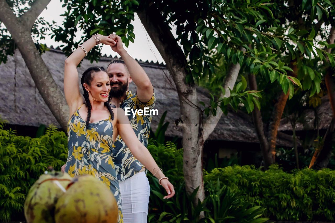 Couple dancing by trees