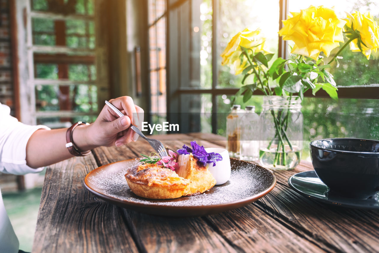 Cropped hand of person holding food on table