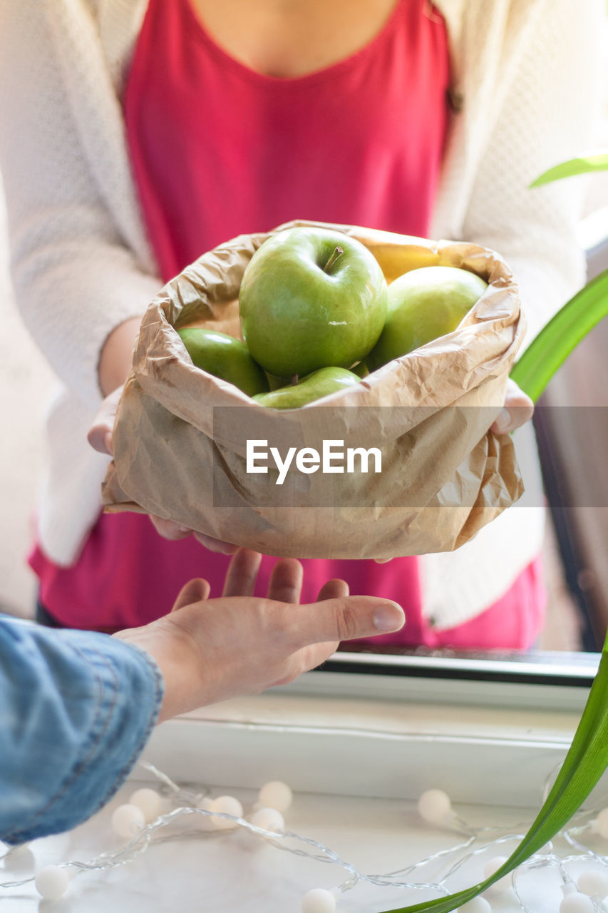 Close-up of people with granny smith apple