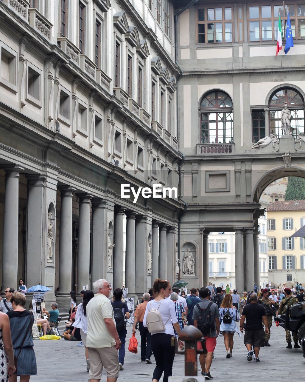 GROUP OF PEOPLE IN FRONT OF BUILDINGS