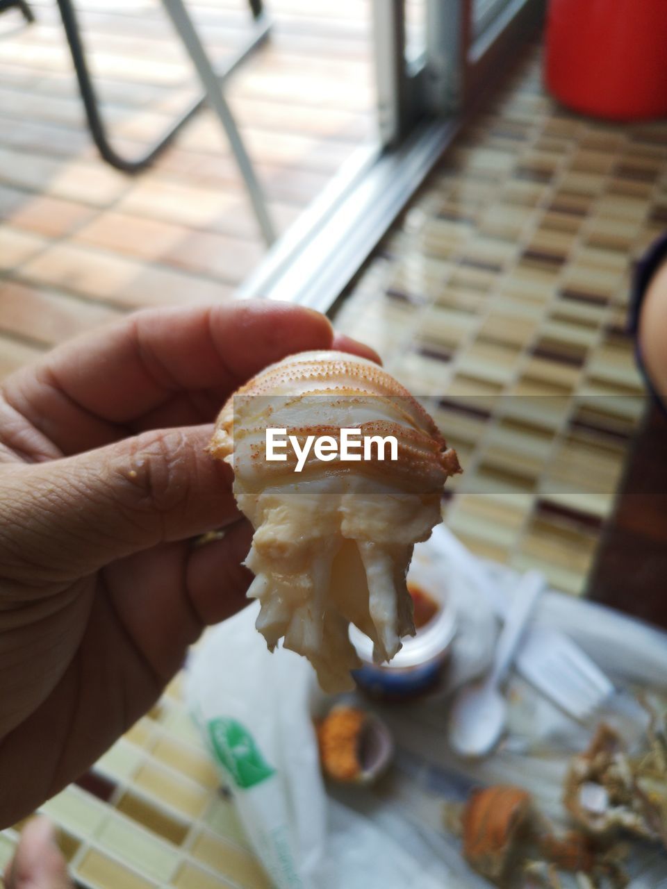 HIGH ANGLE VIEW OF HAND HOLDING BREAD ON TABLE