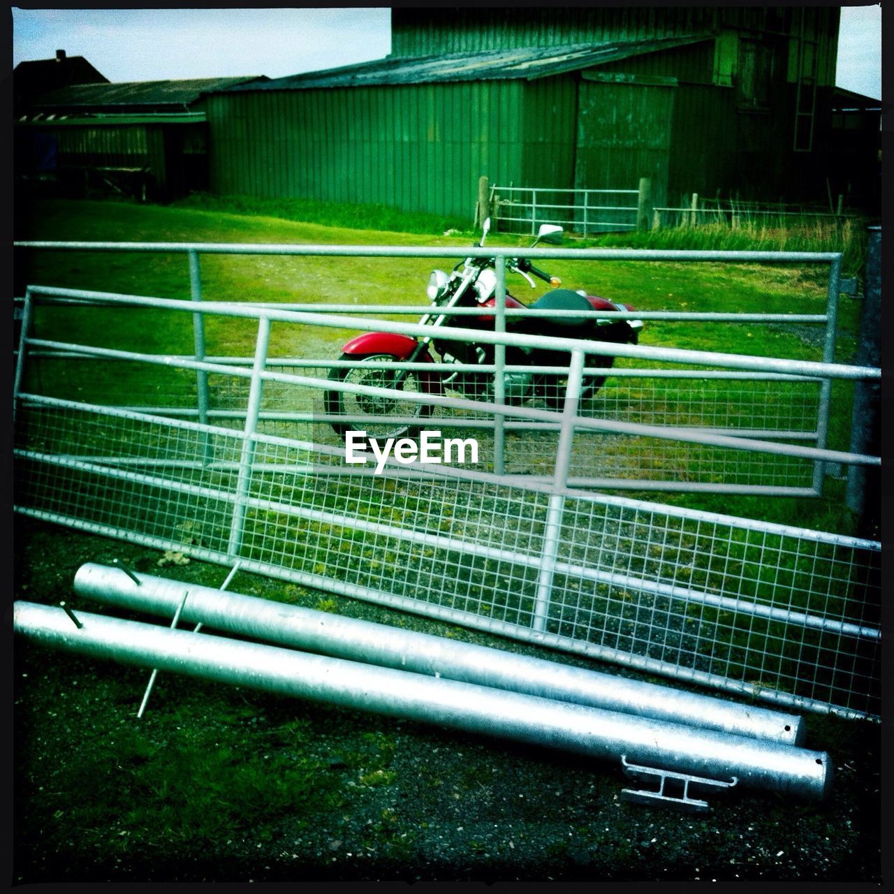 Motorcycle on field by fence against house