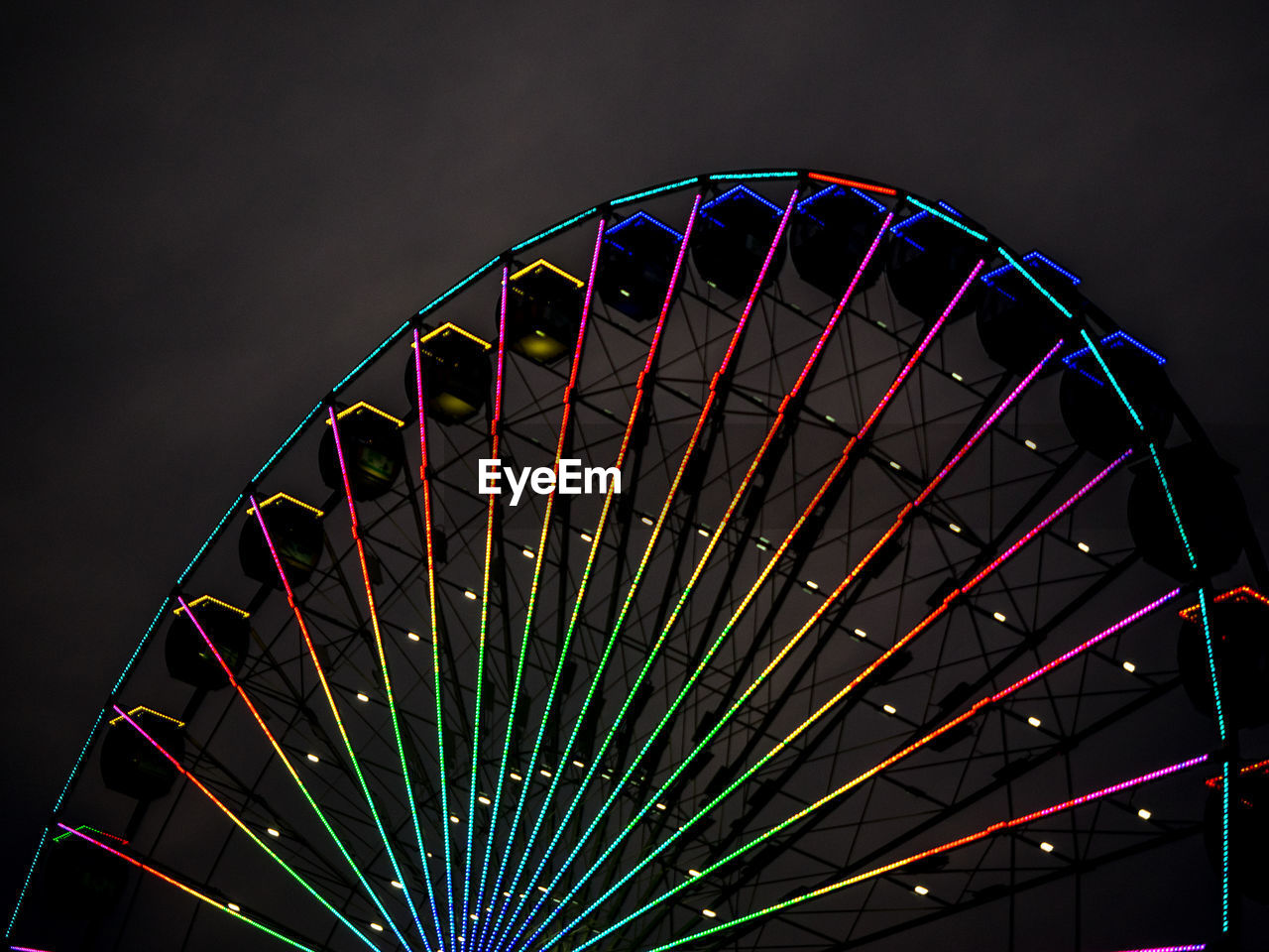 Low angle view of illuminated ferris wheel against sky at night