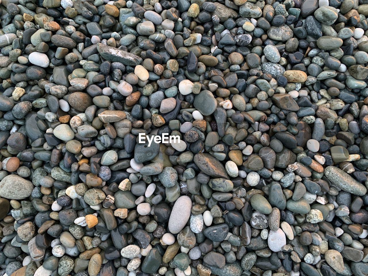HIGH ANGLE VIEW OF STONES IN PEBBLES