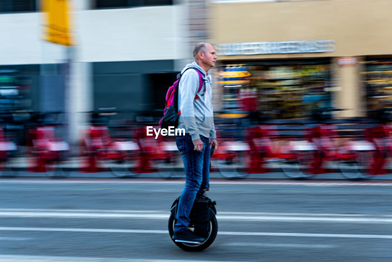 MAN RIDING MOTORCYCLE ON ROAD