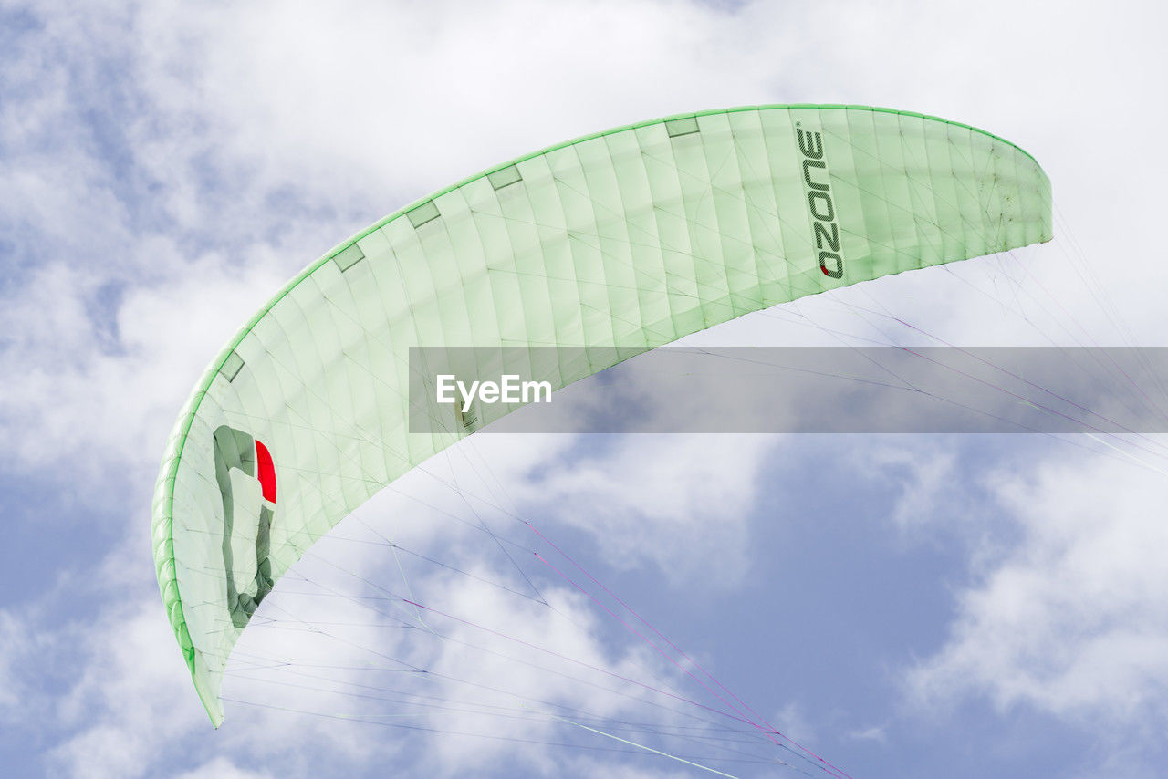 cloud, sky, paragliding, windsports, extreme sports, adventure, parachute, nature, sports, flying, air sports, joy, gliding, leisure activity, environment, transportation, mid-air, low angle view, exhilaration, day, outdoors, parachuting, wing, wind, multi colored, holiday, vacation, trip, blue, green, fun, sign, recreation, motion, sport kite