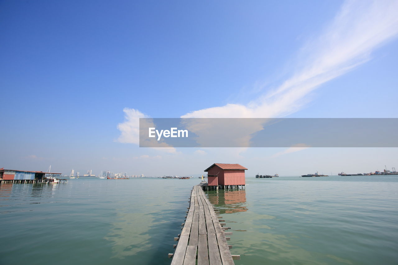 Scenic view of pier by building against sky