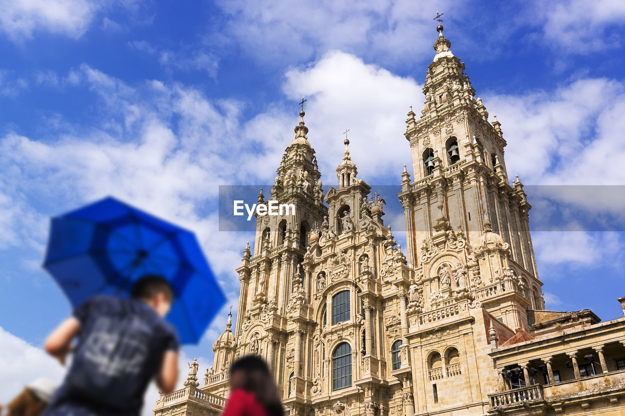 Santiago de compostela cathedral church and tourist guide with umbrella  unfocused  , galicia, spain