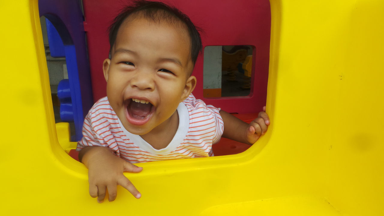 Portrait of cheerful boy playing at playground