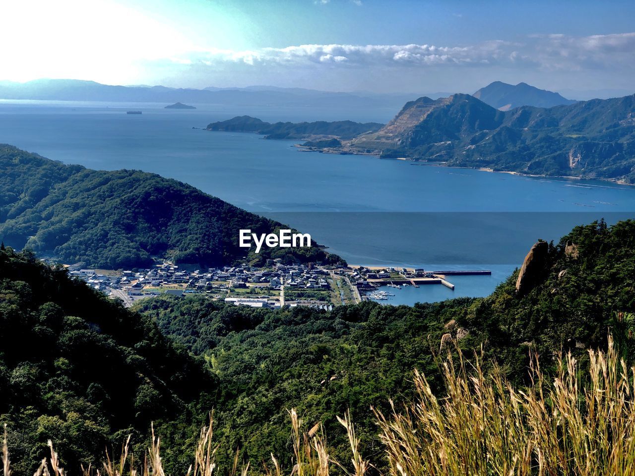 mountain, water, scenics - nature, environment, sky, landscape, beauty in nature, nature, sea, land, travel destinations, travel, plant, mountain range, tranquility, no people, tranquil scene, beach, tourism, coast, cloud, outdoors, architecture, blue, vacation, highland, holiday, trip, non-urban scene, sunlight, coastline, day, tree, idyllic, summer, body of water, wilderness, building, grass