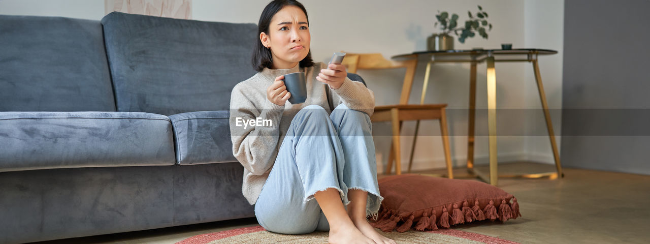 young woman sitting on sofa