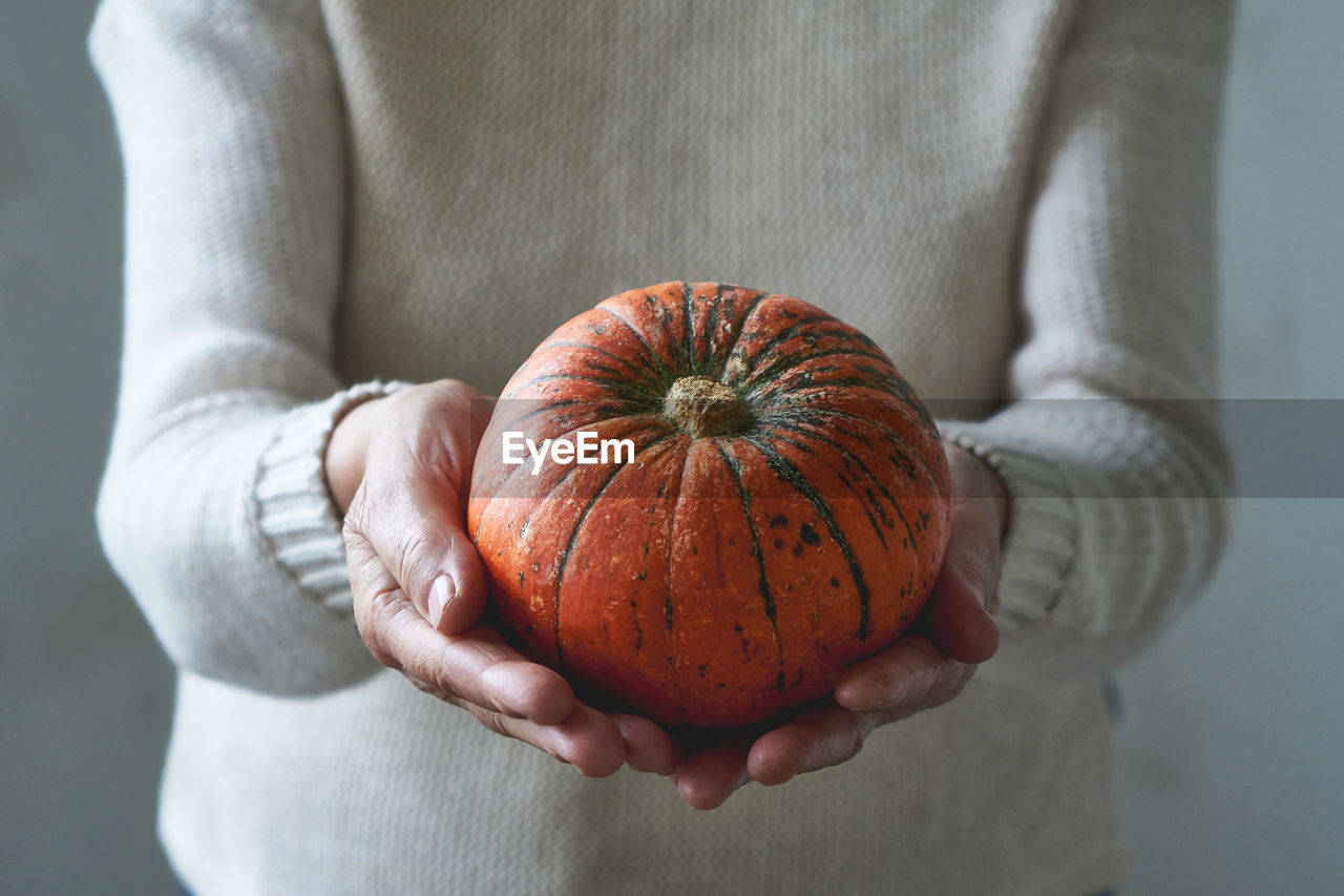 Close-up of hand holding pumpkin