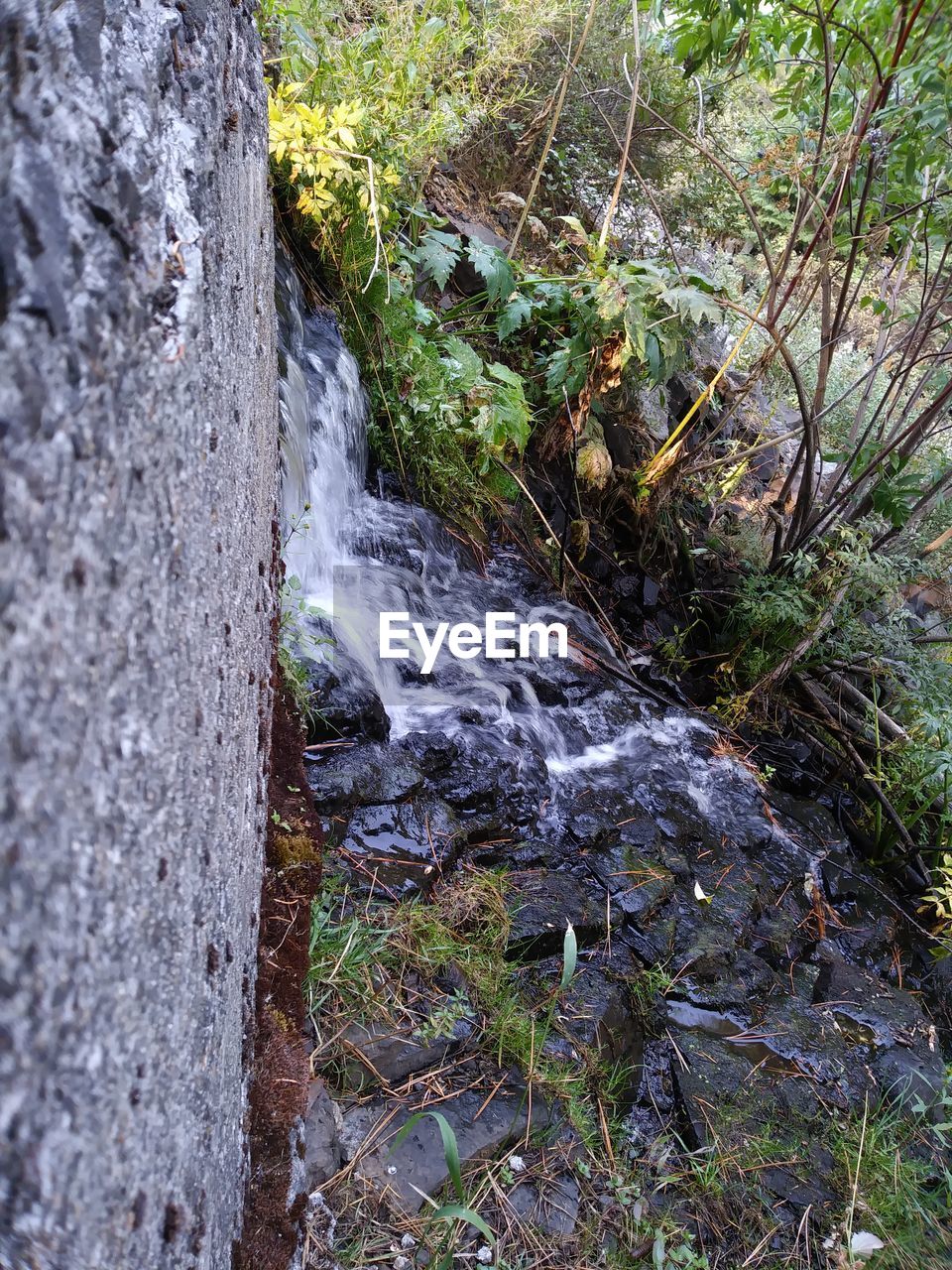 SCENIC VIEW OF WATER FLOWING THROUGH ROCKS