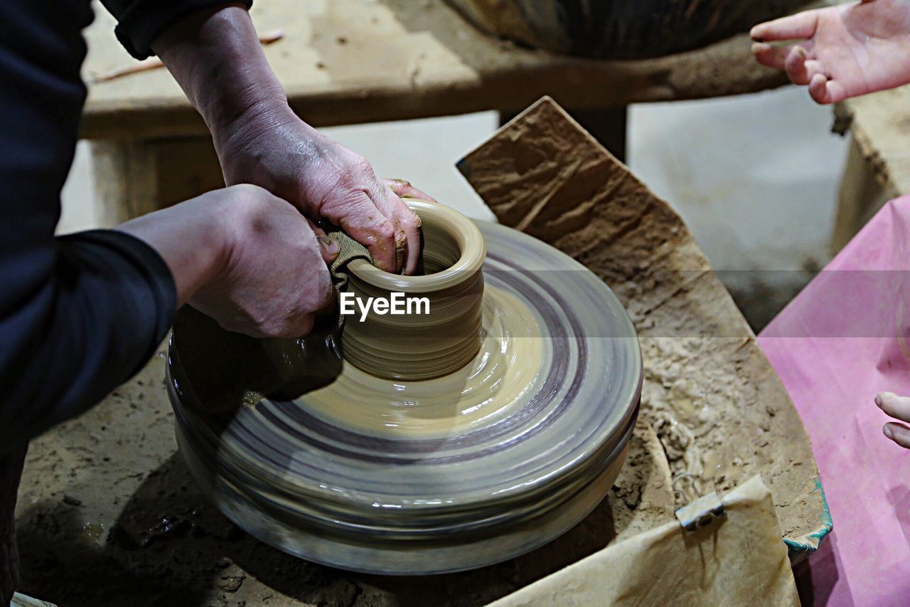 Sculptor making clay pot at workshop