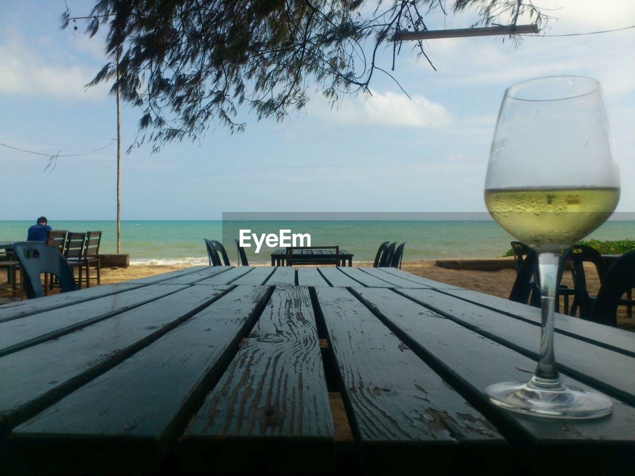 Close-up of white wine on table at beach