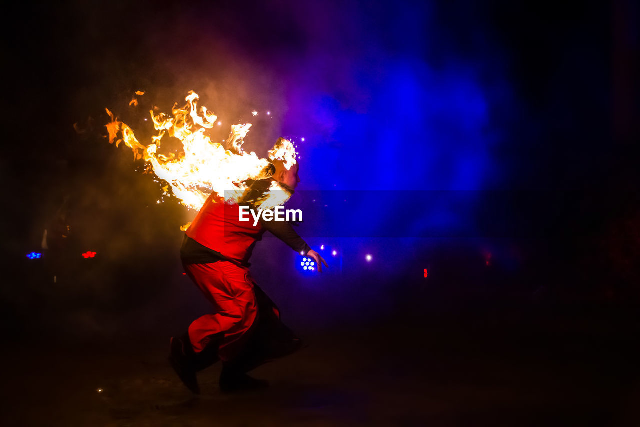 LOW ANGLE VIEW OF ILLUMINATED FIREWORKS AT NIGHT