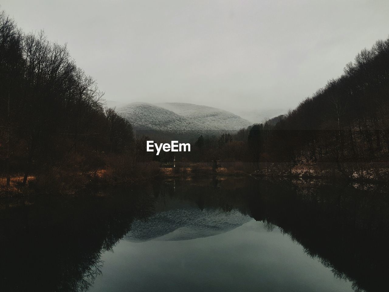 Scenic view of lake against sky during winter